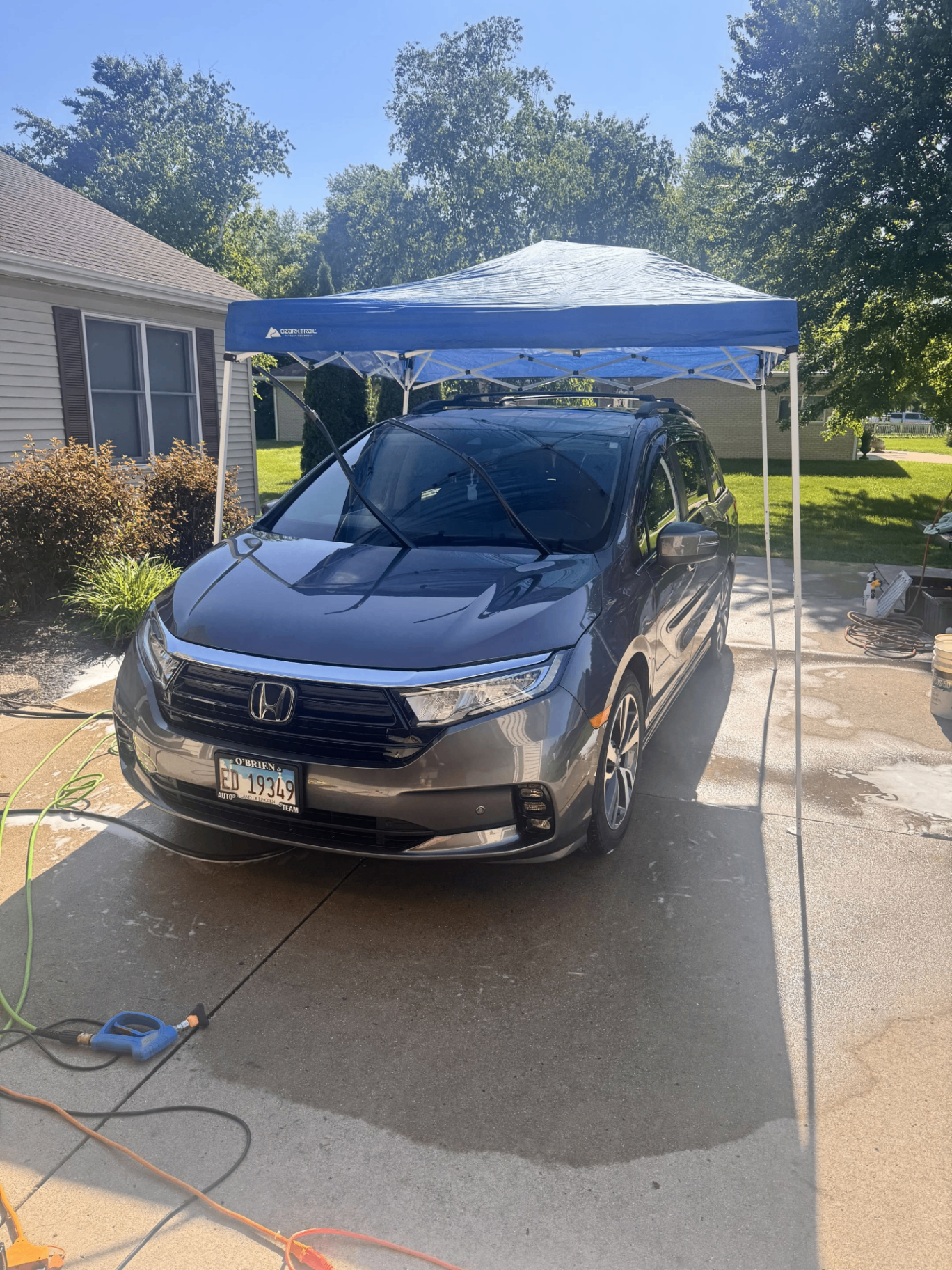 Honda Odyssey being washed under a pop-up canopy